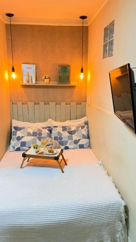 a bedroom with a bed with a table and a tv at Loft Charmoso Privativo in Volta Redonda
