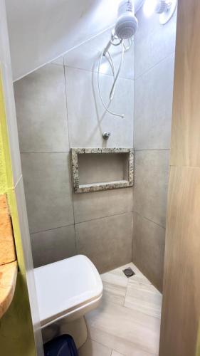 a small bathroom with a toilet and a shower at Loft Charmoso Privativo in Volta Redonda