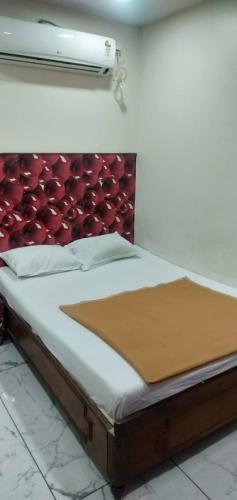 a bedroom with a bed with a red headboard at Amith Comforts near to Railway Station in Mysore