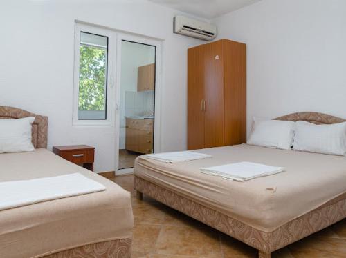 a hotel room with two beds and a window at Apartments Music in Sutomore