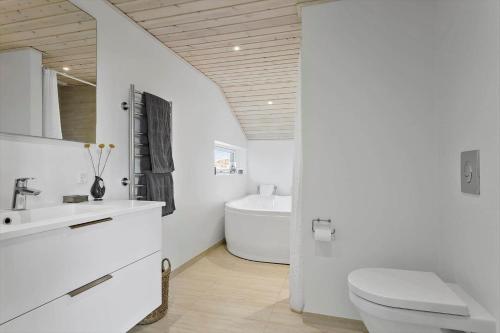 a bathroom with a toilet and a sink and a tub at LN1865-Hirtshals-Krageklit-30 in Hirtshals