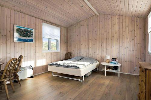 a bedroom with a bed and a table and chairs at LN1865-Hirtshals-Krageklit-30 in Hirtshals