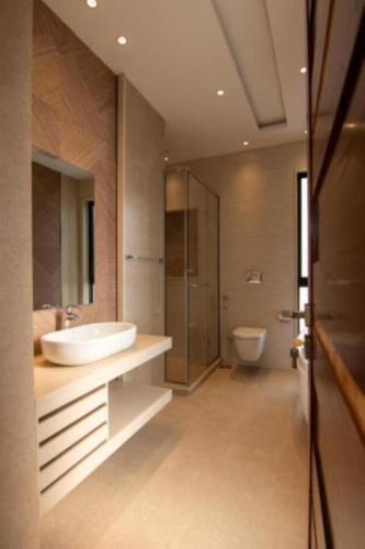 a bathroom with a sink and a toilet at Hotel Elysian By G K Group Near IGI Delhi Airport in New Delhi