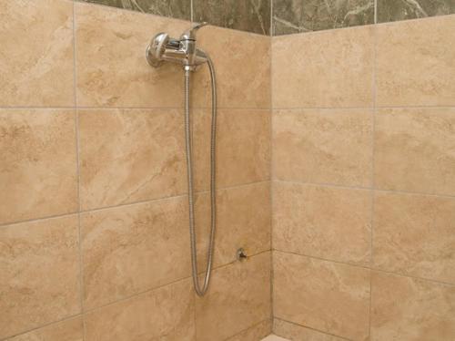 a shower with a shower head in a bathroom at Apartments Music in Sutomore