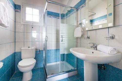 a blue and white bathroom with a toilet and a sink at Villa Zeus in Spartià