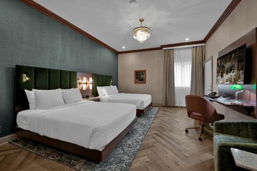 a hotel room with two beds and a desk at The Miners 1928 Hotel in Pottsville