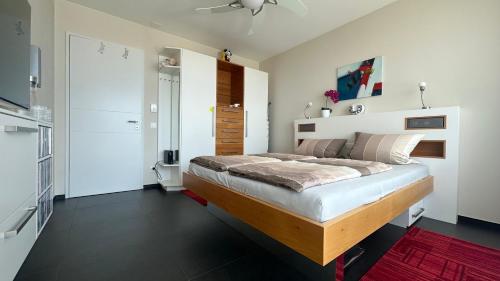 a bedroom with a large bed with white walls at Room Casa Jessika in Orselina
