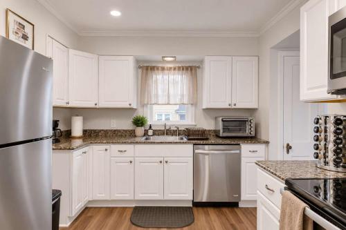 a kitchen with white cabinets and a stainless steel refrigerator at Center Field All Star Baseball Rentals in Oneonta