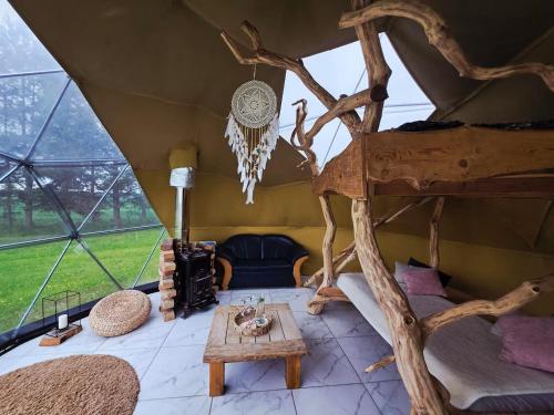 a room in a tent with a bed and a table at Kupolinis namelis Miško Pašvaistėje in Balneliškiai