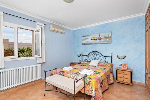 a blue bedroom with a bed and a window at Villa Dori by Villa Select in Punta Prima