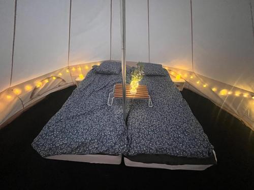 a bedroom with a bed with a candle on it at Glamping on the waterfront in Hammarland