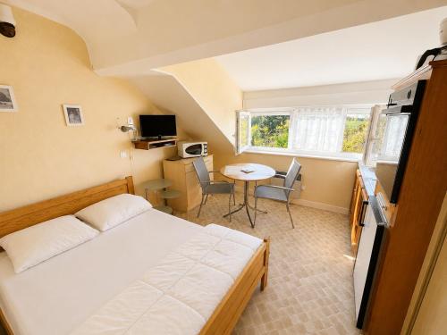 a small room with a bed and a table at Aux Coquelicots in Saint-Honoré-les-Bains