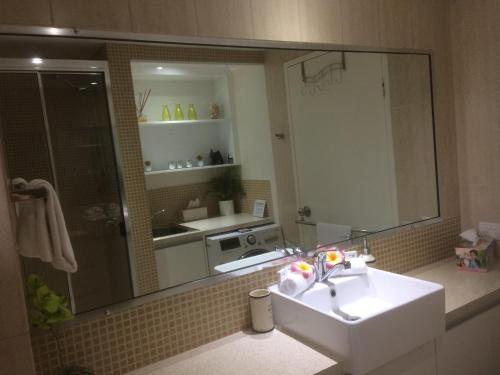 uma casa de banho com um lavatório e um espelho em Paradise in the Tropics em Palm Cove