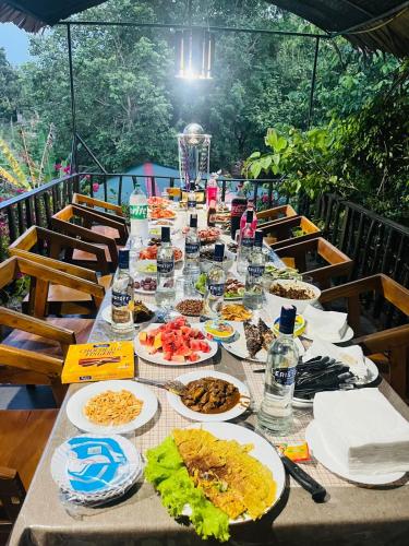 a long table with plates of food on it at Cottage Wild Boar in Udawalawe