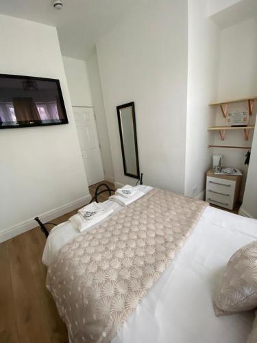 a bedroom with a large white bed with a mirror at Alexander's luxury rooms all en-suite, spa bath in Blackpool