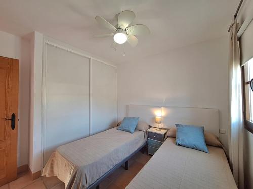 a bedroom with two beds and a ceiling fan at Harbour Lights IV in Villaricos