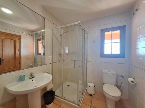 a bathroom with a toilet and a sink and a shower at Harbour Lights IV in Villaricos