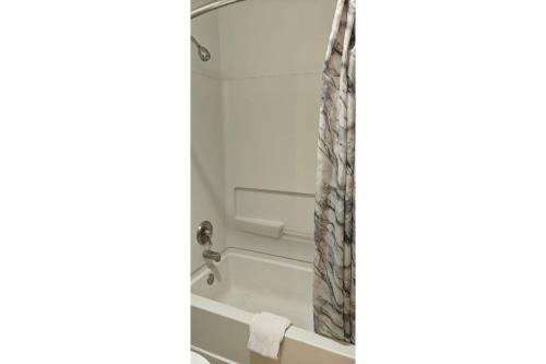 a bathroom with a shower curtain and a tub at Albuquerque Inn Near Airport I 40 in Albuquerque