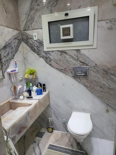 a bathroom with a toilet and a tv on the wall at Nashwa m mohamed in Ain Sokhna