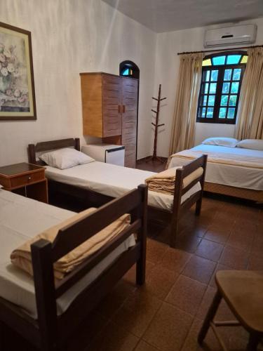 a room with three beds in a room at Hotel Pousada Cavalo Marinho in Boicucanga