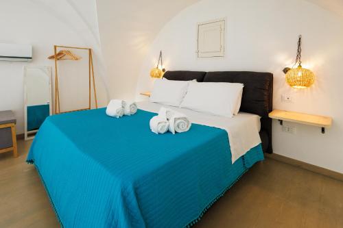 a bedroom with a blue bed with towels on it at Miria B&B in Castrignano del Capo