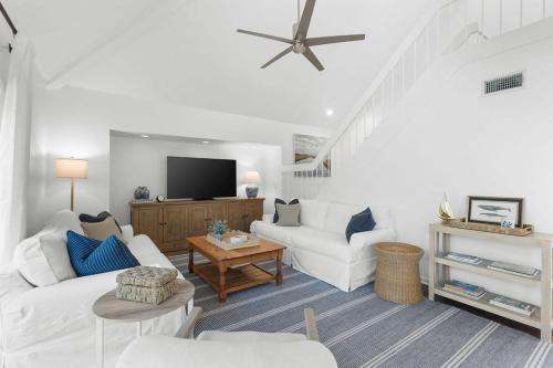 a living room with white furniture and a flat screen tv at 774 Spinnaker Beach House in Seabrook Island