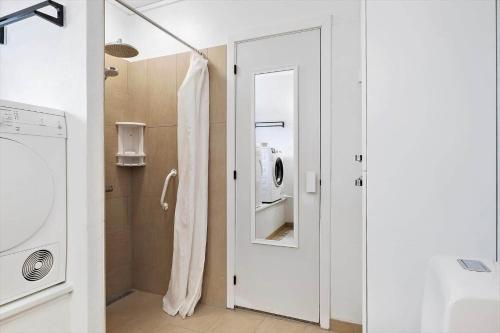 a bathroom with a washing machine and a mirror at LN1913-Hjorring-Rubjergvej-11 in Hjørring