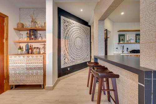 a kitchen with a bar with stools and a counter at Playa Potrero Beachfront Ocean Views, Pool & BBQ in Santa Cruz