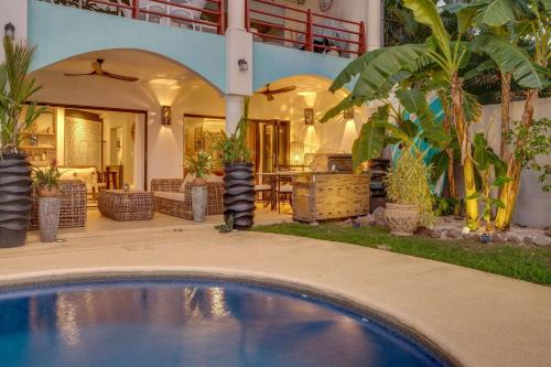 a house with a swimming pool in front of a house at Playa Potrero Beachfront Ocean Views, Pool & BBQ in Santa Cruz