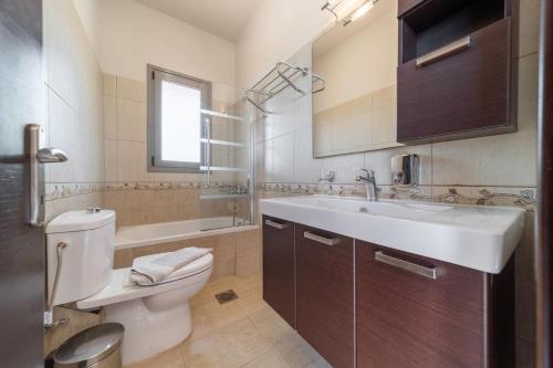 a bathroom with a sink and a toilet and a tub at Villa Anna by Villa Select in Skala