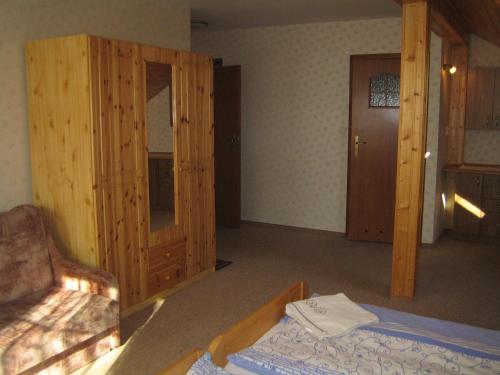 a room with a bed and a wooden cabinet at Nasz Domek in Karpacz