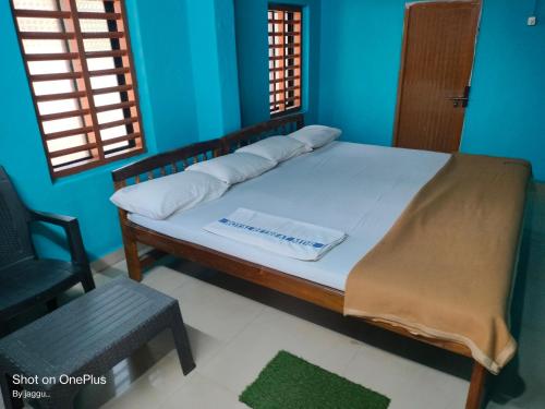 a bed in a room with a chair and a window at Totadamane in murdeshwar in Māvalli