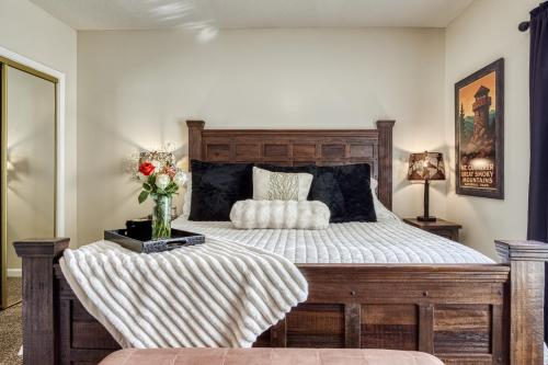 a bedroom with a wooden bed with a vase of flowers at 2 King BRs Balcony Resort Amenities Free Tix in Pigeon Forge
