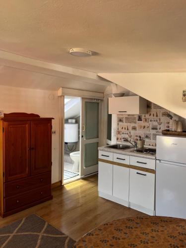 a kitchen with white cabinets and a staircase at Studios Jacobus in Korčula