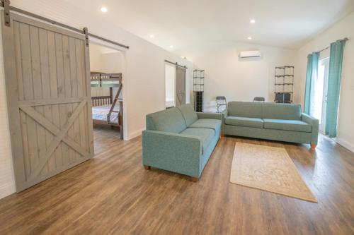 a living room with two couches and a sliding barn door at Sun Outdoors Cape May in Cape May