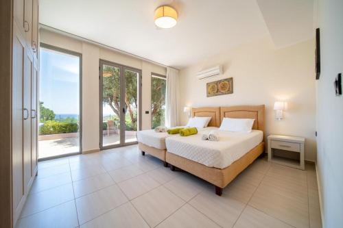 a bedroom with a bed and a large window at Villa Anna by Villa Select in Skala