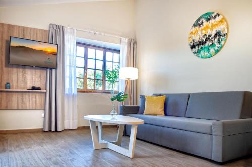 a living room with a blue couch and a table at Maspalomas Villas by Dunas - Adults Only in Maspalomas