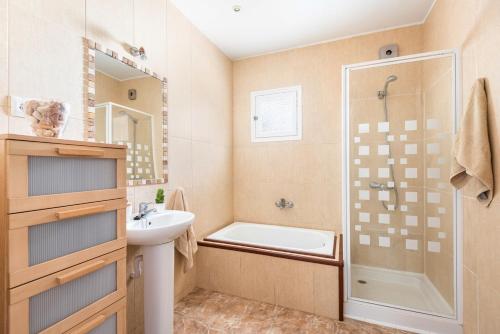 a bathroom with a sink and a shower and a tub at Villa Dulcesol by Villa Select in Alaior