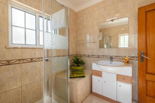 a bathroom with a shower and a sink and a mirror at Villa Fatima by Villa Select in Galé