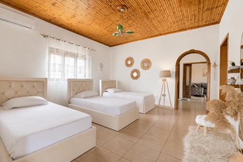 a bedroom with two beds and a wooden ceiling at Villa Kevin in Berat