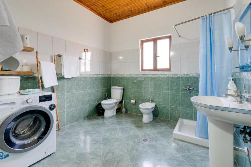 a bathroom with a washing machine and a toilet at Villa Kevin in Berat
