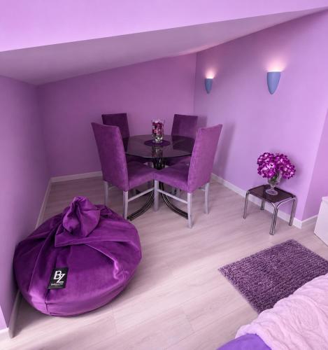 a purple dining room with a table and purple chairs at Hotel Kamelia in Varna City