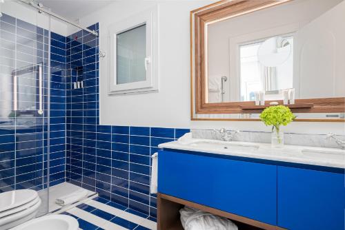 a blue tiled bathroom with a sink and a toilet at Villa Lia Hotel Capri in Capri