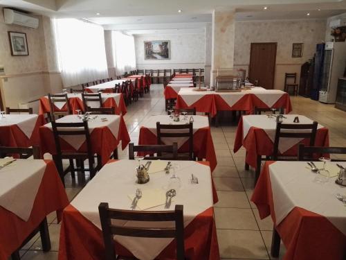 a dining room with red and white tables and chairs at Hotel Trasimeno Bittarelli in Castiglione del Lago