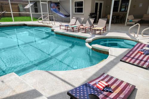 a swimming pool with chairs and an american flag at Splash & Relax Games WiFi BBQ Fire Pit Boat Lake in Royal Palm Beach