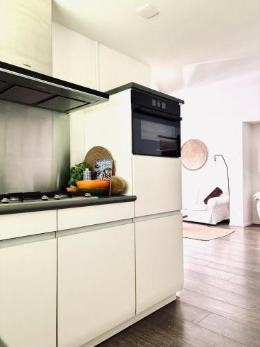 a kitchen with white cabinets and a stove top oven at Prive rustplek op de Veluwe met jacuzzi in Ermelo