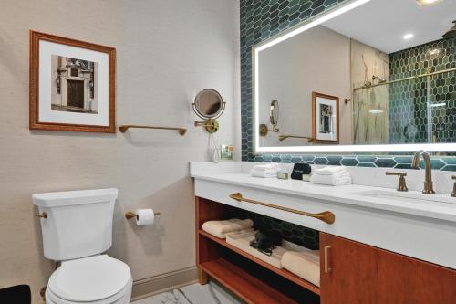 a bathroom with a sink and a toilet and a mirror at The Miners 1928 Hotel in Pottsville