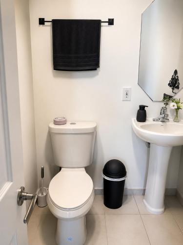 a white bathroom with a toilet and a sink at Miami Stay - Pool, Parking, & Affordable Transportation in Tamiami