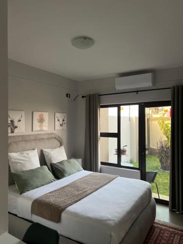 a bedroom with a large bed and a large window at Ekuku Snug in Oshakati