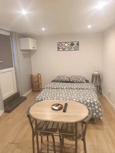 a bedroom with a bed and a table with a table at Studio charmant in Sedan